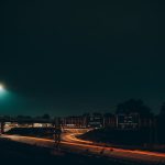 Captivating long exposure shot of Indianapolis highway at night with light trails and road signs.